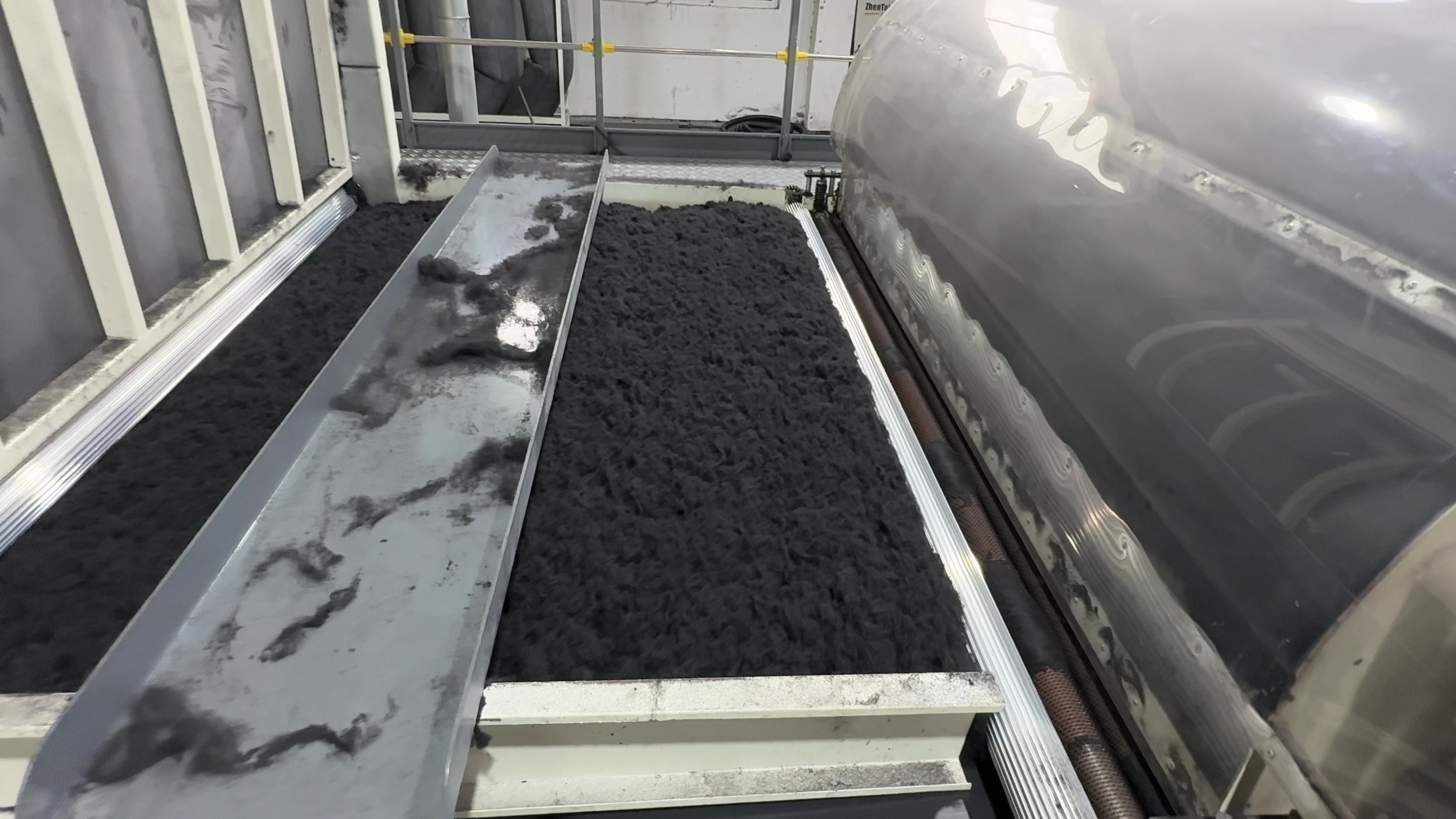 本厂原布加工现场：深色纤维经过输送工位。